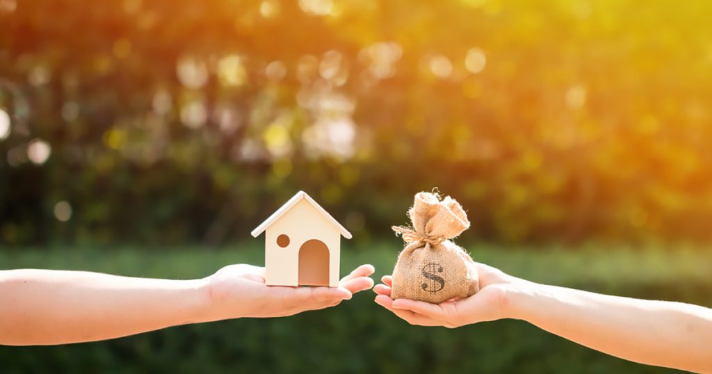 Loans for real estate concept, a man and a women hand holding a money bag and a model home put together in the public park., Investment Lending, Real Estate Investment